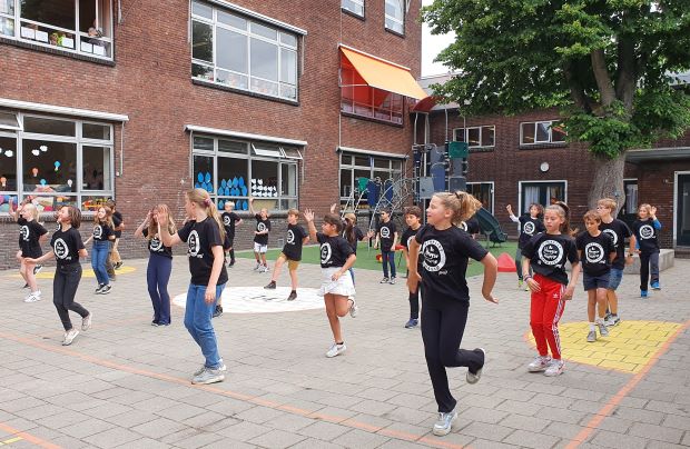 aantal basisscholieren doen mee aan een gymles op het schoolplein: een gezonde school is een school waar leerlingen de ruimte krijgen voor voldoende lichaamsbeweging