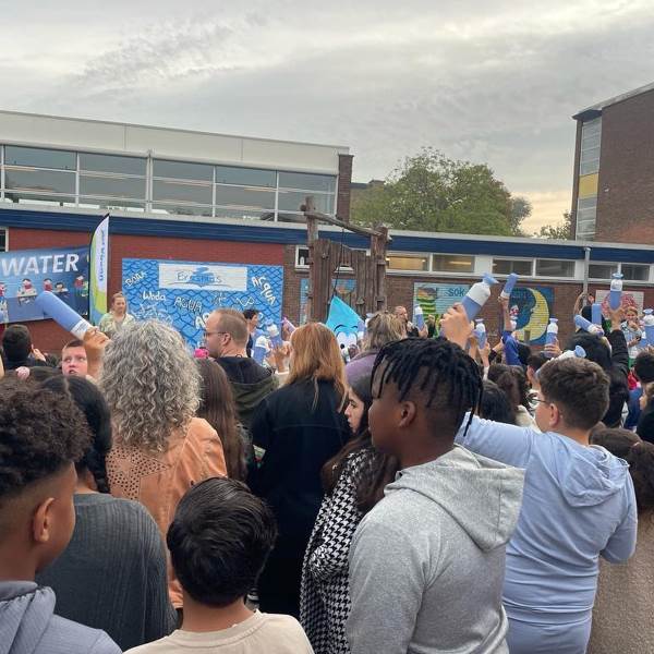Het schoolplein van OBS Erasmus staat vol kinderen en ouders, wachtend op de onthulling van de nieuwe watertap.