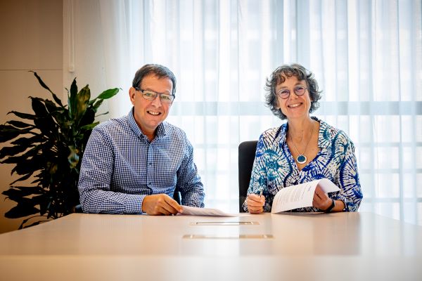 Bestuurder Ron Boumans van JGZ Zuid-Holland West en directeur Publieke Gezondheid Annette de Boer van GGD Haaglanden kijken lachend in de camera na het ondertekenen van de samenwerkingsafspraken in het kader van de pandemische paraatheid
