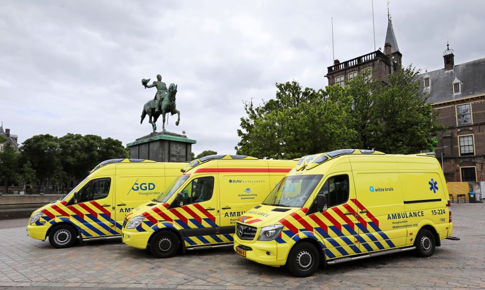 3 ambulances van RAV Haaglanden voor een standbeeld vlakbij het Binnenhof in Den Haag